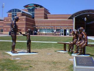 Some statues outside the park. There are also Midwest League Plaques, a fountain, and two large digital announcement boards.